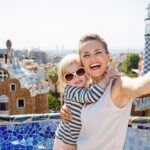 Barcelona will show you how to remarkably spend holiday. Smiling mother and baby taking selfie at Park Guell