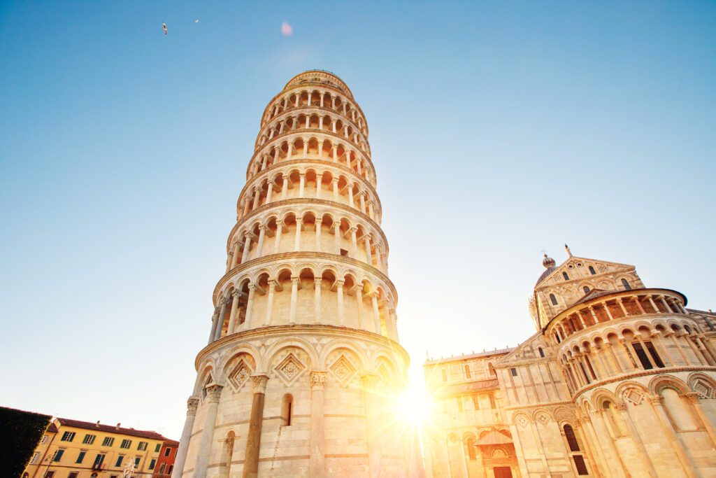 Pisa leaning tower and cathedral basilica at sunrise, Italy.