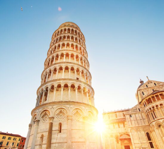 Pisa leaning tower and cathedral basilica at sunrise, Italy.