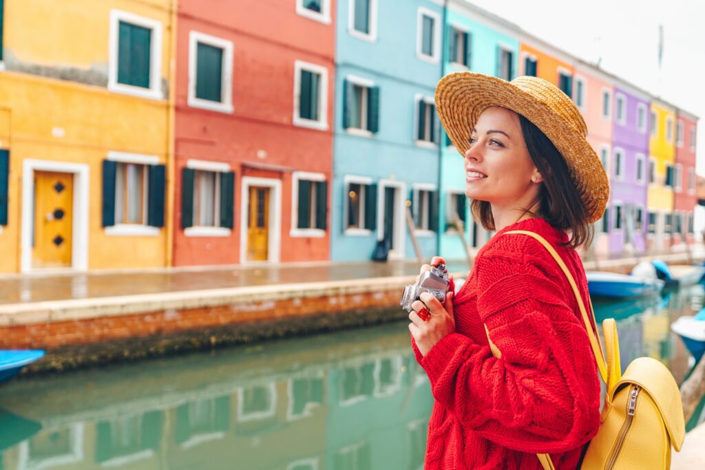 Beautiful young girl with a retro camera in Burano