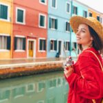 Beautiful young girl with a retro camera in Burano