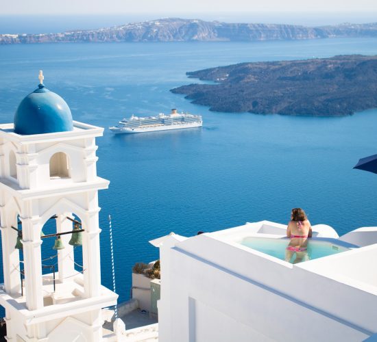 Best Tour Operators Us / A serene and picturesque view of Santorini, Greece, characterized by the iconic white architecture with blue domes.