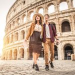 Young couple at the Colosseum, Rome - Happy tourists visiting italian famous landmarks